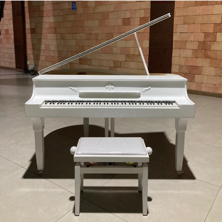 Piano digital de cauda branco com banco, visto de frente